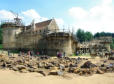 Guédelon : construction du château (année 2013), château à mi construction au milieu des rochers et visiteurs