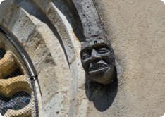 Fondremand : statue tête humaine à côté de la rosace 