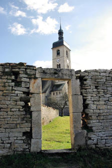 Ornans : église Saint Laurent vue à travers une porte de mur  en pierres