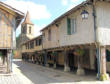 Tillac : rue principale avec maisons à piliers fleuris
