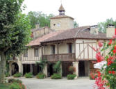 Fourcés : Tour de l'horloge derrière maisons à pan de bois