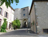 Cordes sur Ciel-porte fortifiée et tour en haut d'une rue pavée