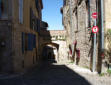 Cordes sur Ciel-maisons, rue pavée en descente vers porte médiévale