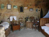 Meschers  ( les grottes Régulus ) intérieur des grottes, une chambre avec lit,chaises , meuble, miroir