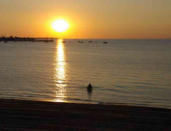 Fouras : coucher de soleil sur bateaux et baigneur à la source de Fouras