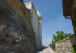 Grignan : rue autour du château bordée de rochers et de remparts