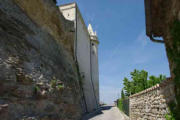 Grignan : rue autour du château bordée de rochers et de remparts