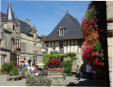 Rochefort en Terre : place du village - fontaine fleurie - parterre de fleurs - maisons à pan de bois et d'autres en pierres