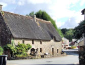 Lanvaudan : maison à toit de chaume avec puit en bordure de route