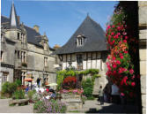 Rochefort en Terre : place du village - fontaine fleurie - parterre de fleurs - maisons à pan de bois et d'autres en pierres
