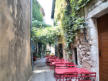 La Garde Adhémar : tables et chaises de restaurant dans une ruelle