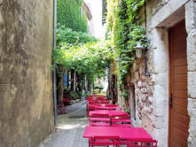 La Garde Adhémar : tables et chaises de restaurant dans une ruelle