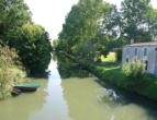 Coulon   ( le marais poitevin )  autre canal avec barques et maison